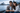 Couple sitting  by Sydney Harbour looking at a smartphioe with Sydney Opera House in the background