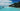 tropical beach location with beach huts and deep blue sea 