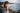 Woman in a white dress using a smartphone by Noosa beach