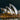 The Sydney Opera House illuminated at night, with its white shell-like roof structures glowing against a dark sky and water reflections below.